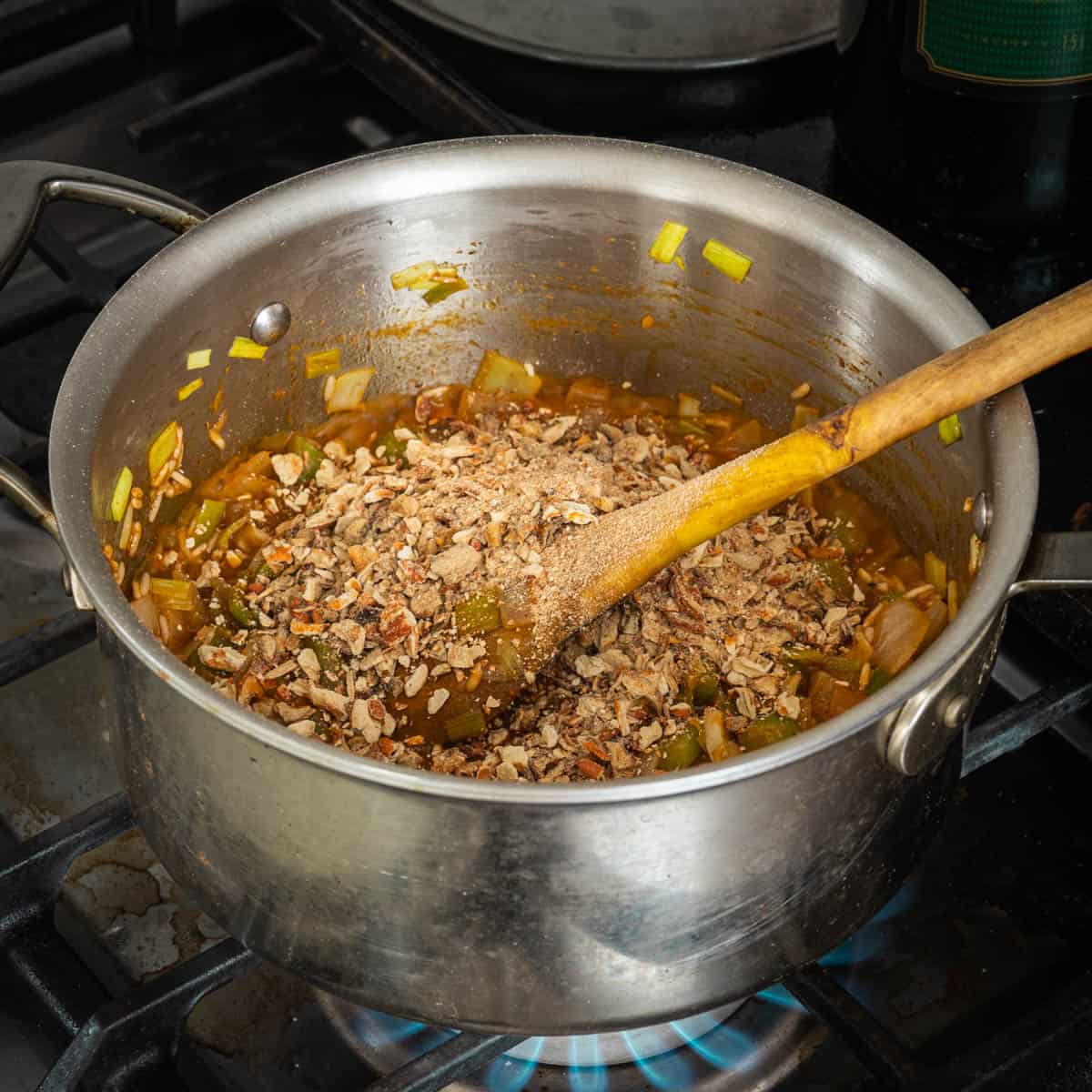 adding dried mushrooms to a pot of soup