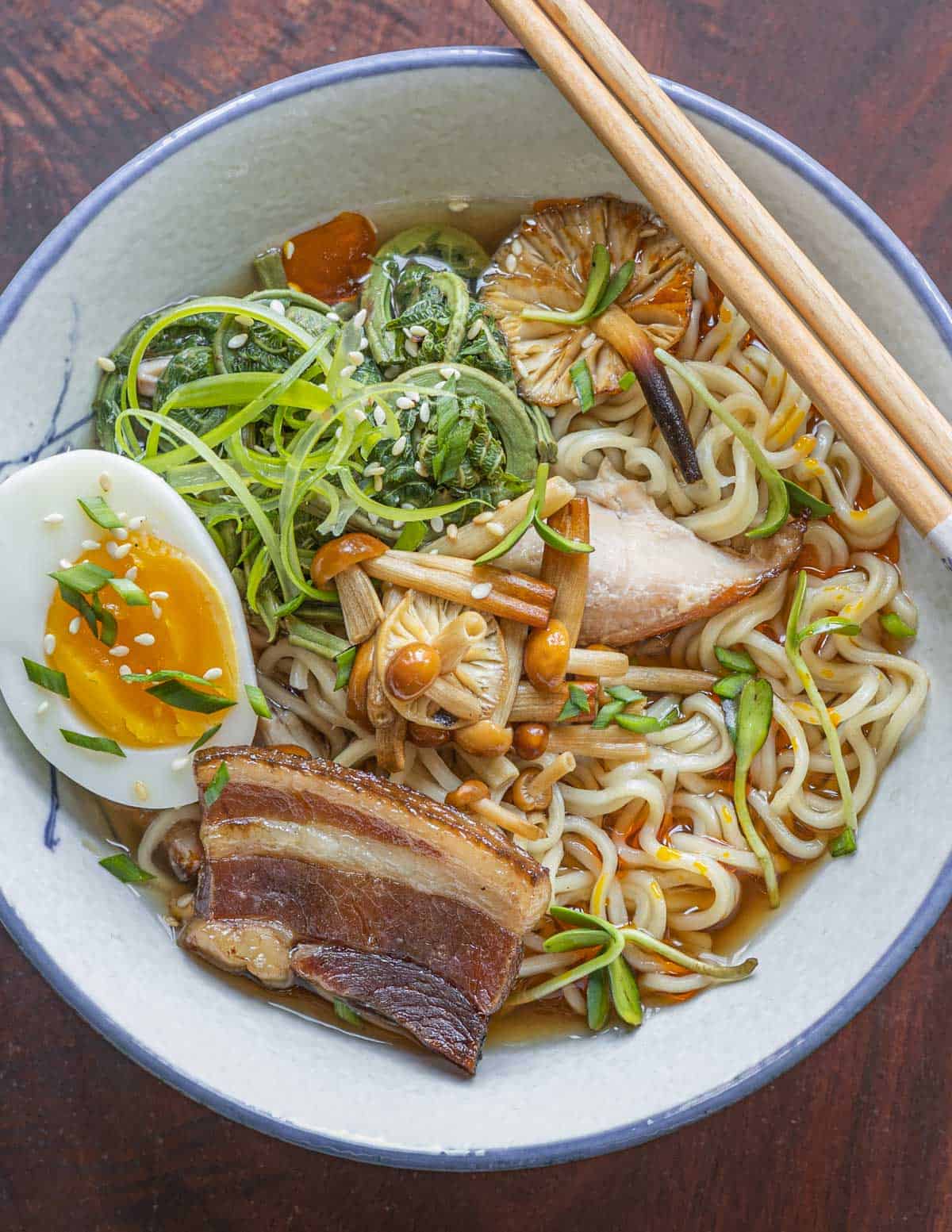 A bowl of ramen with enoki mushrooms.