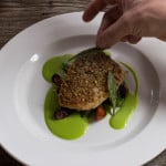 Plating Sunflower seed crusted whitefish with two lillies, peas and carrots