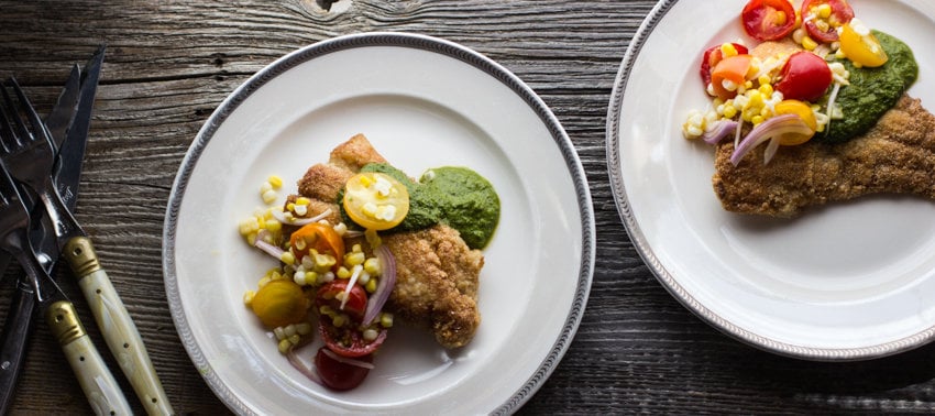 cornmeal fried catfish with salad and herb sauce on a plate 