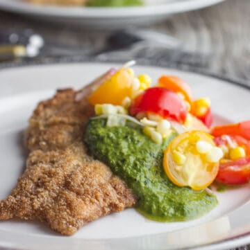 cornmeal fried catfish with green herb sauce on a plate