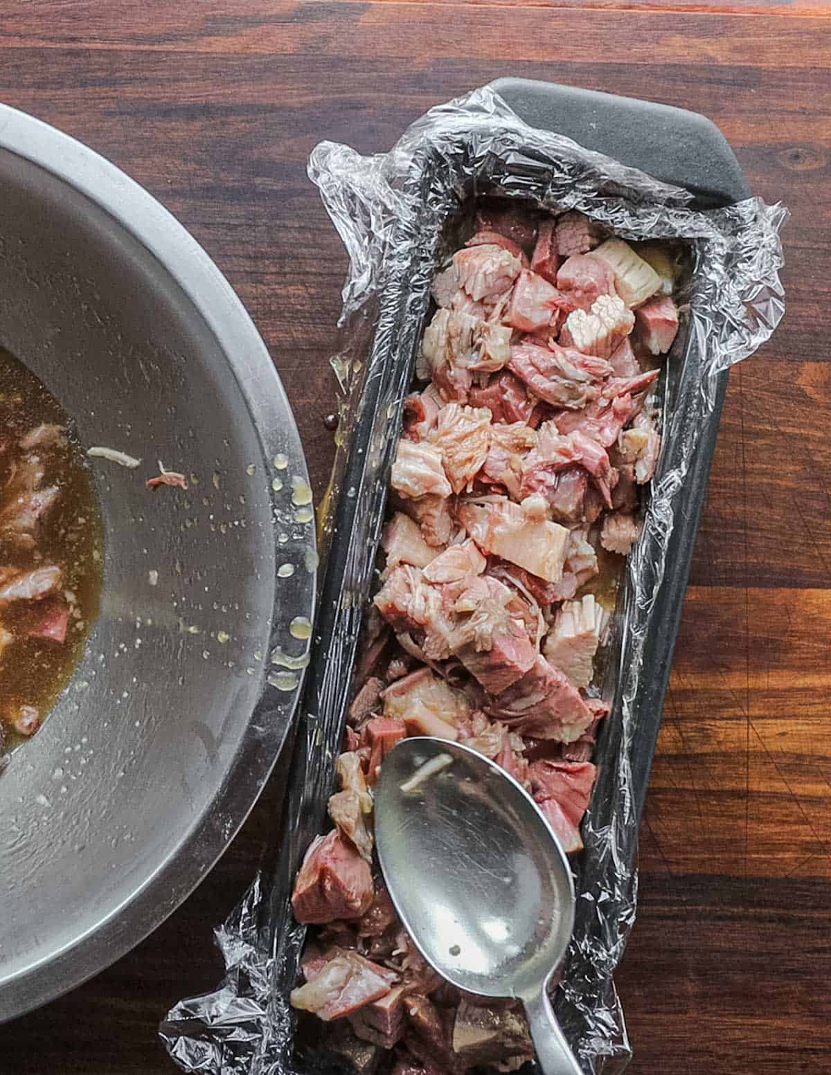 Packing cooked pork meat and liquid into a mold pan or terrine. 