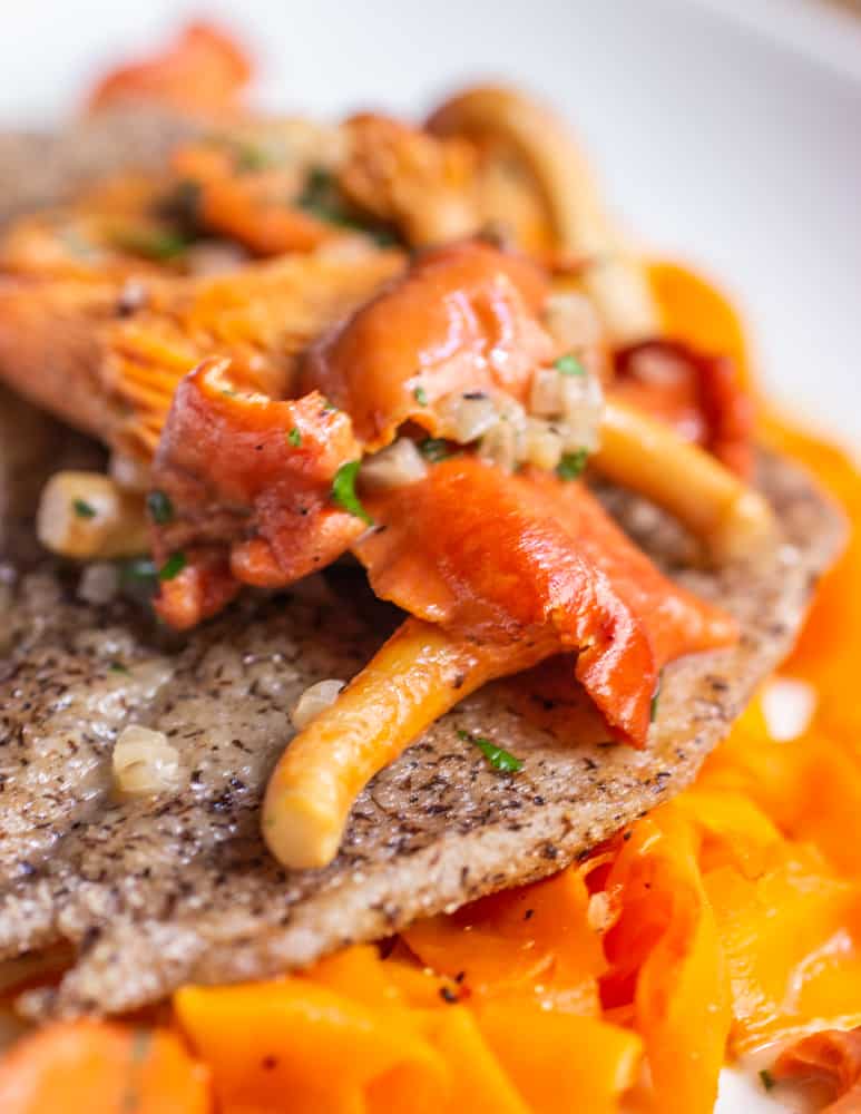 red chanterelle mushrooms on top of buckwheat crusted sole with carrot ribbons