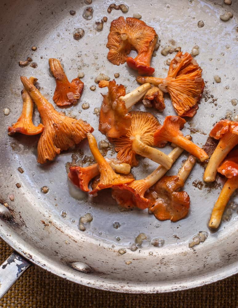 Cooking red chanterelle mushrooms in a pan 
