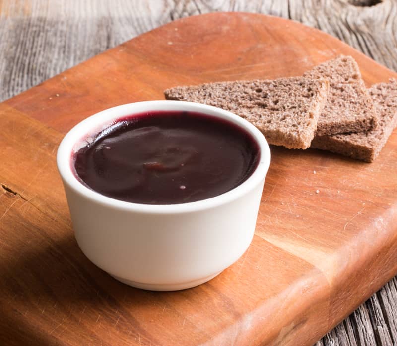 a ramekin of liver mousse topped with jelly served with toast 