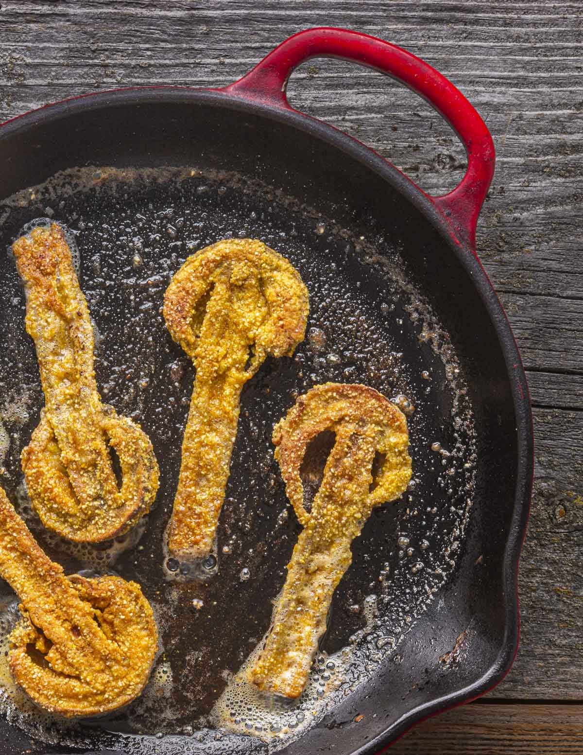 Cornmeal fried parasol mushrooms i in a cast iron pan. 