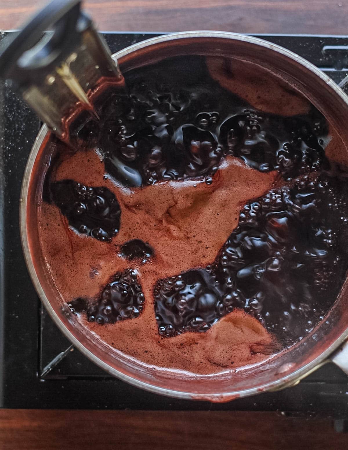 A pot of boiling elderberry jelly.