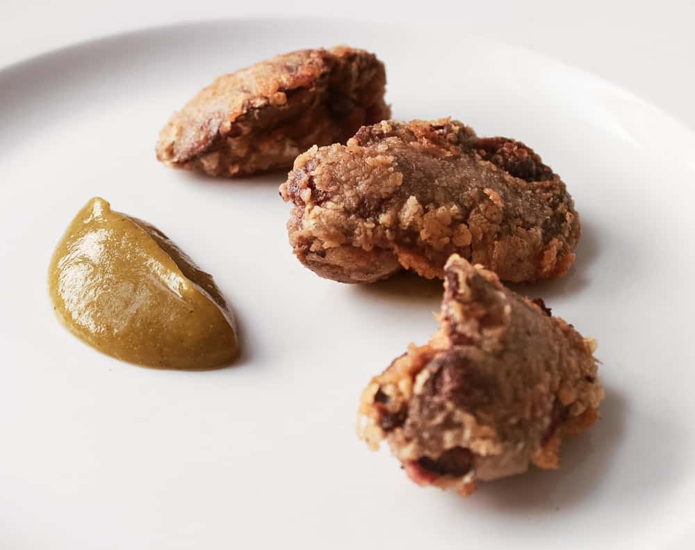 fried chicken livers with green tomato jam on a plate 