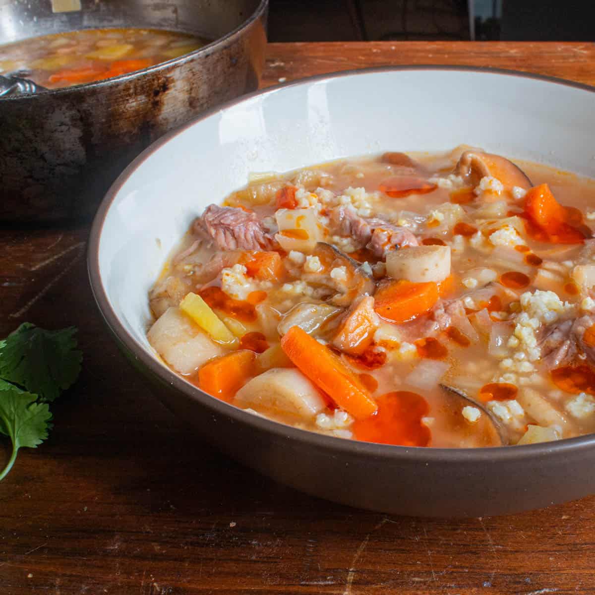 Pork short rib and burdock root soup, with millet, cilantro and chili oil