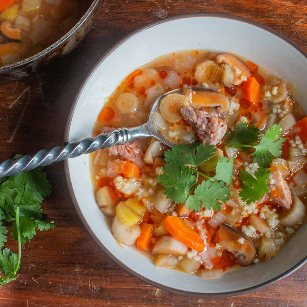 Pork short rib and burdock root soup, with millet, cilantro and chili oil