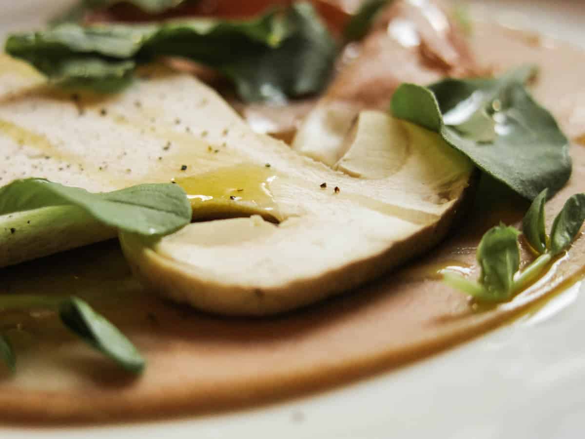 raw porcini mushrooms and cured meats on a plate 