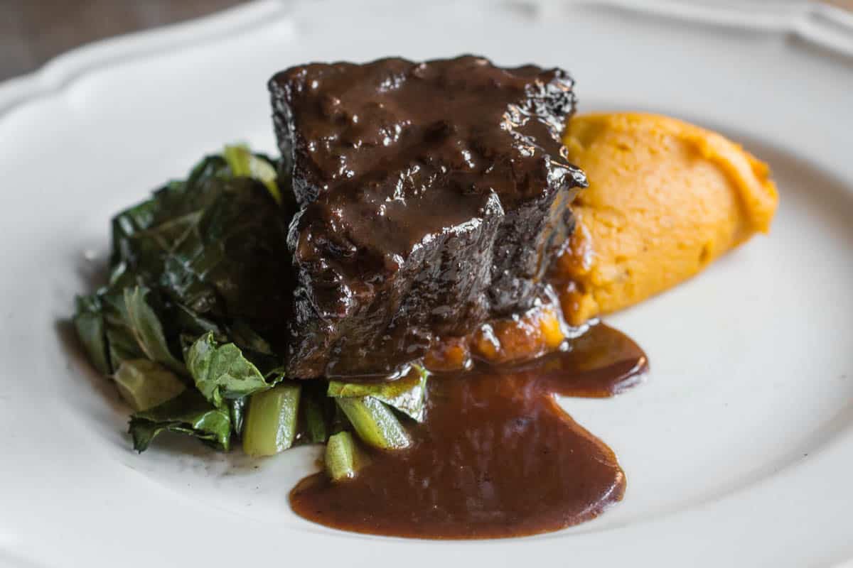 Bison braised in wild grape juice with kabocha squash puree and collards