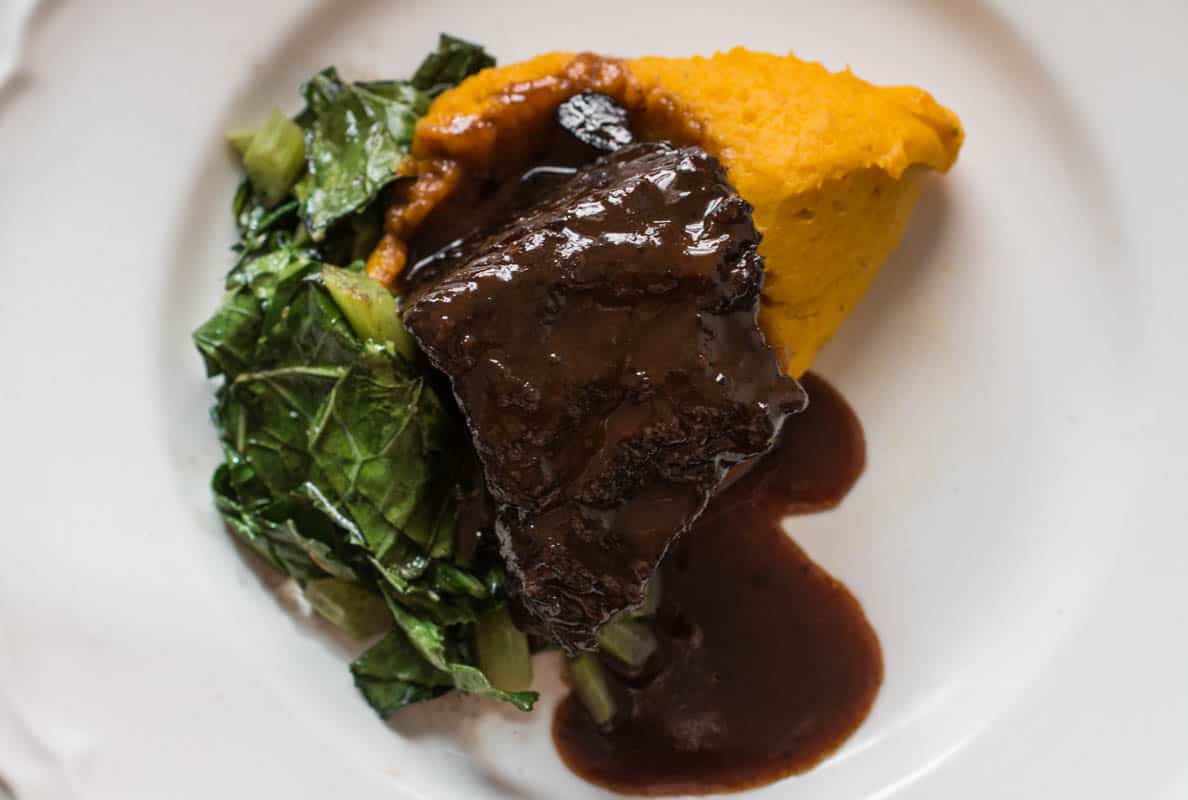 Bison braised in wild grape juice with kabocha squash puree and collards