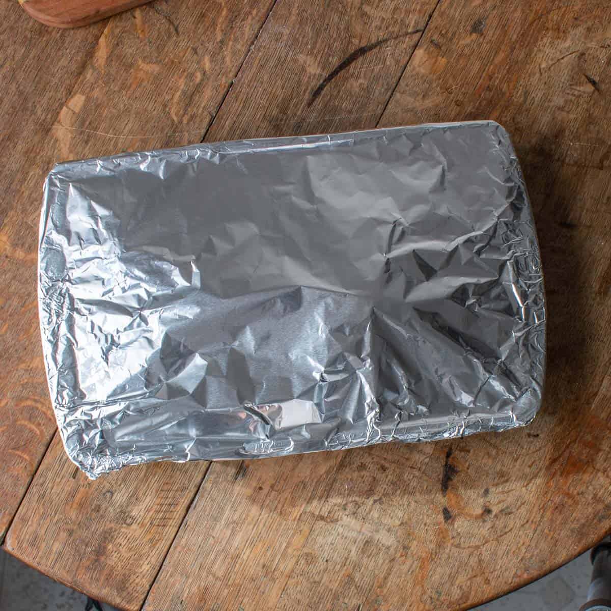 a pan of lamb breast covered with aluminum foil 