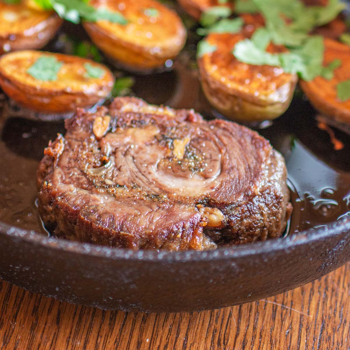 sliced lamb in a pan with potatoes