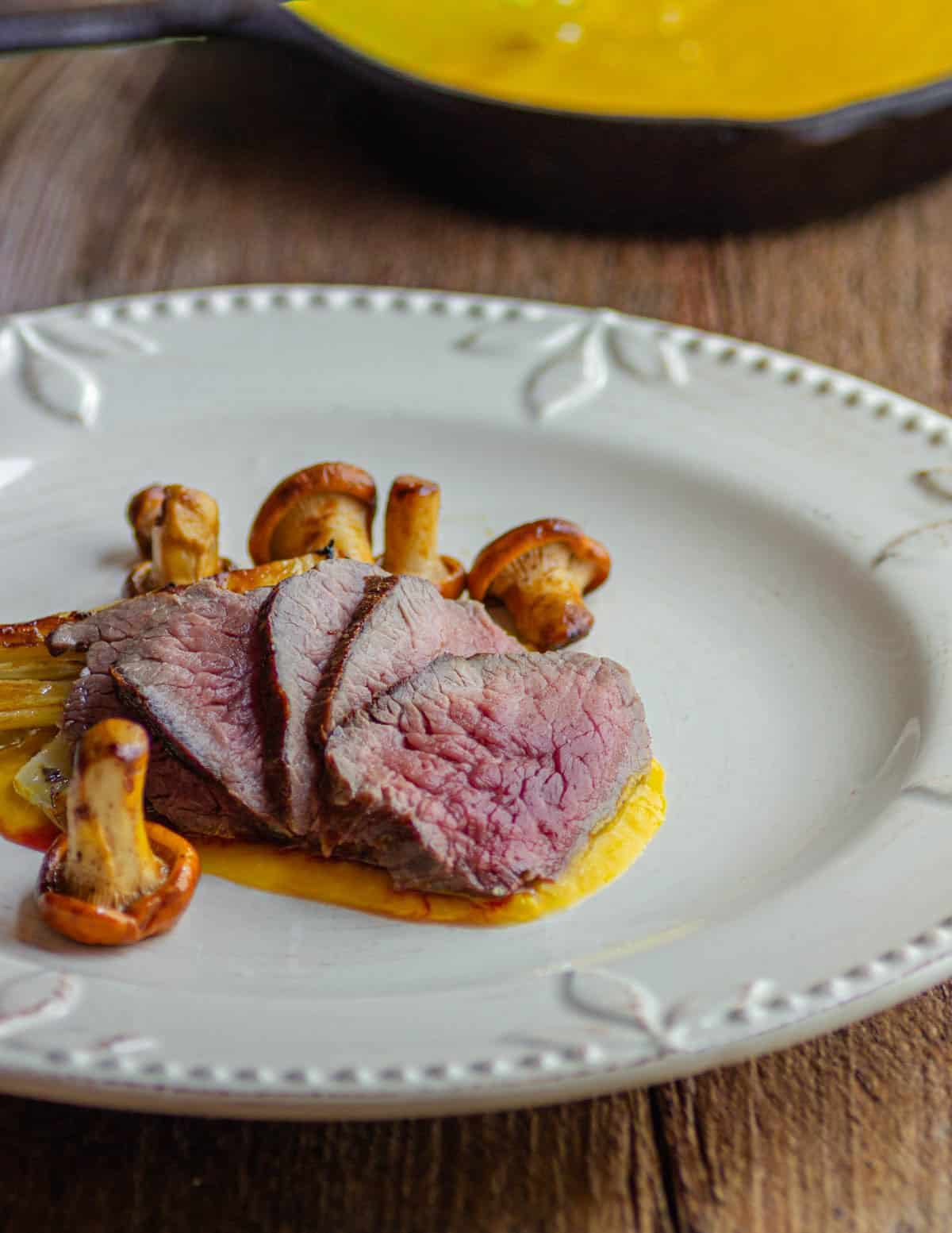 Elk roast rubbed with wild juniper served with pepper coulis and sauteed chanterelles.