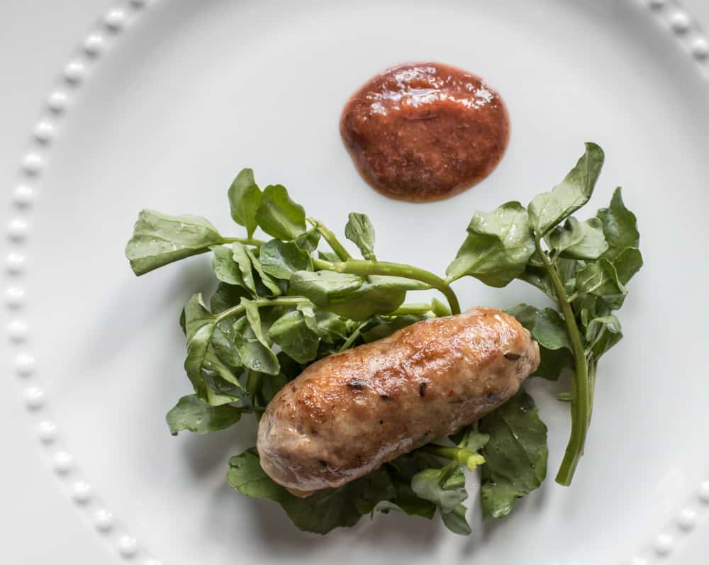 Wild fennel sausage confit with watercress and wild plum sauce