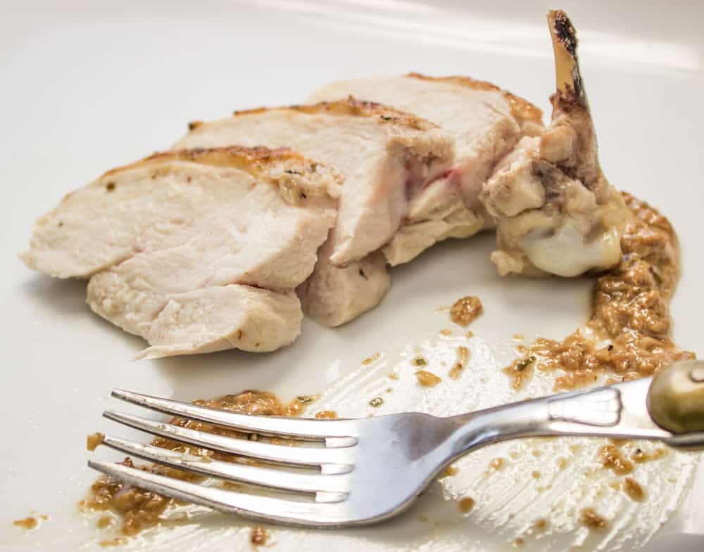 sliced chicken being eaten with a fork 