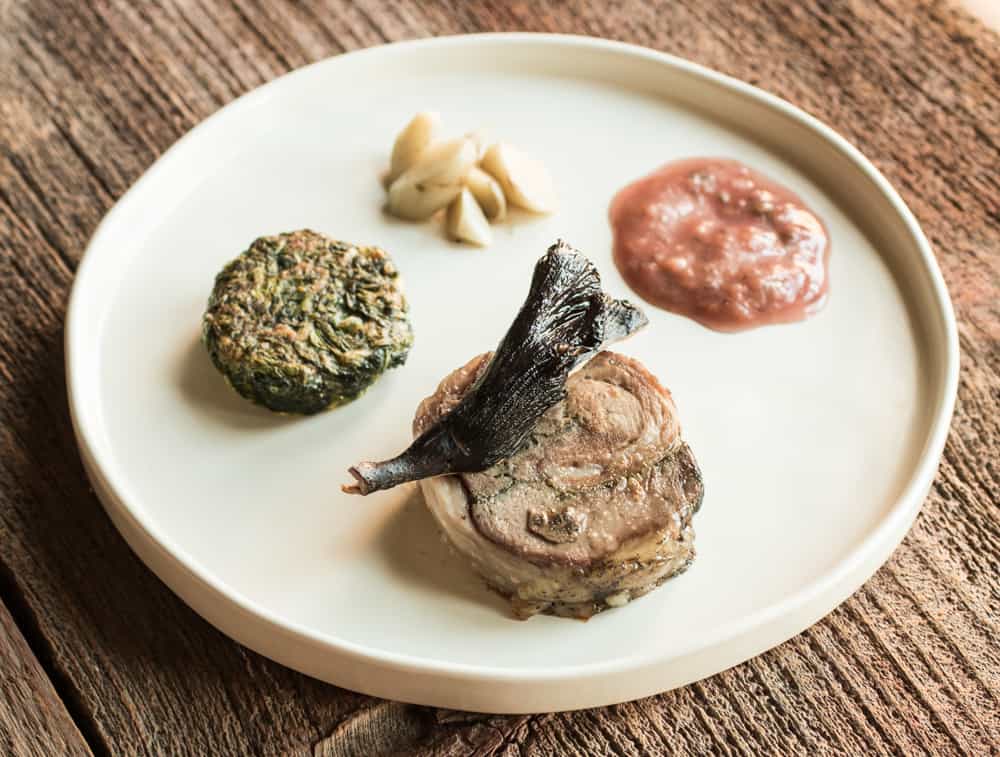 ½ lamb roulade (lambchetta) with tkemali sauce, horseradish leaves, burdock root and pig ear mushrooms