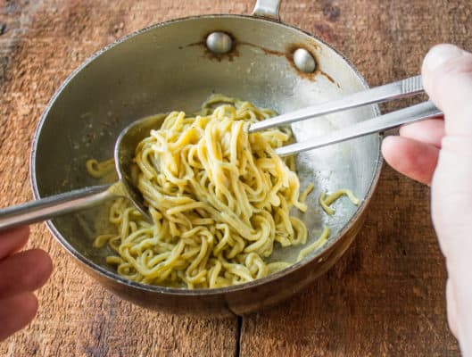duck egg spaghetti with cattail pollen, cattail shoot relish and edible marigolds