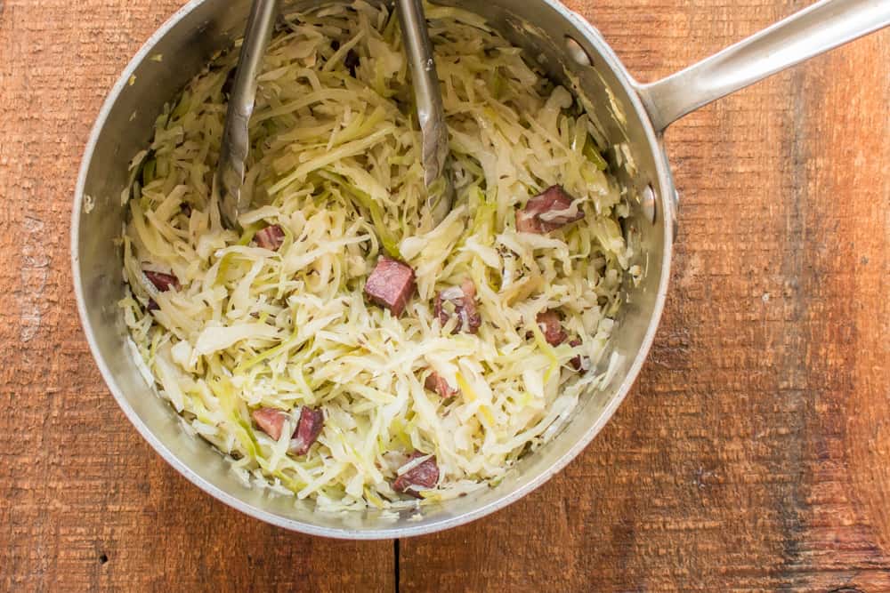 a pan of cooked cabbage with bacon 