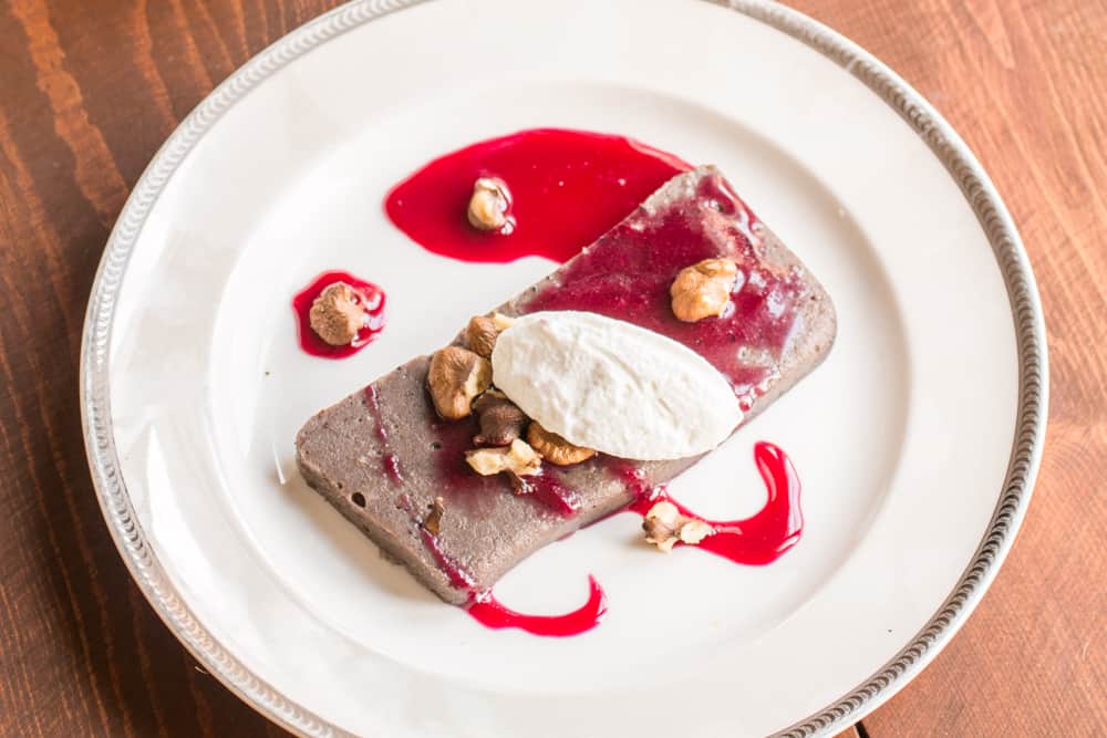 Nannyberry pudding with black walnuts, whipped cream, and chokecherry syrup