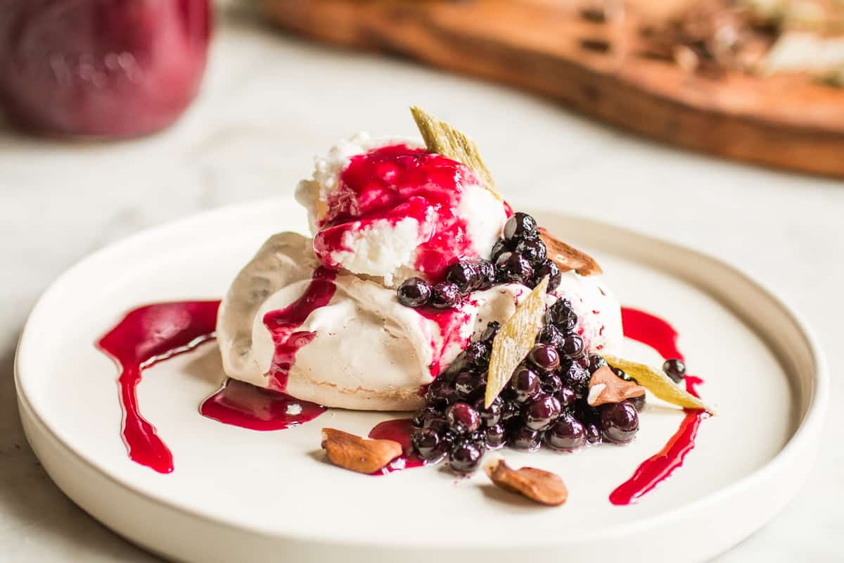 Winter pavlova with meadowsweet ice cream, chokecherry sauce, wild blueberries, butternuts and angelica 