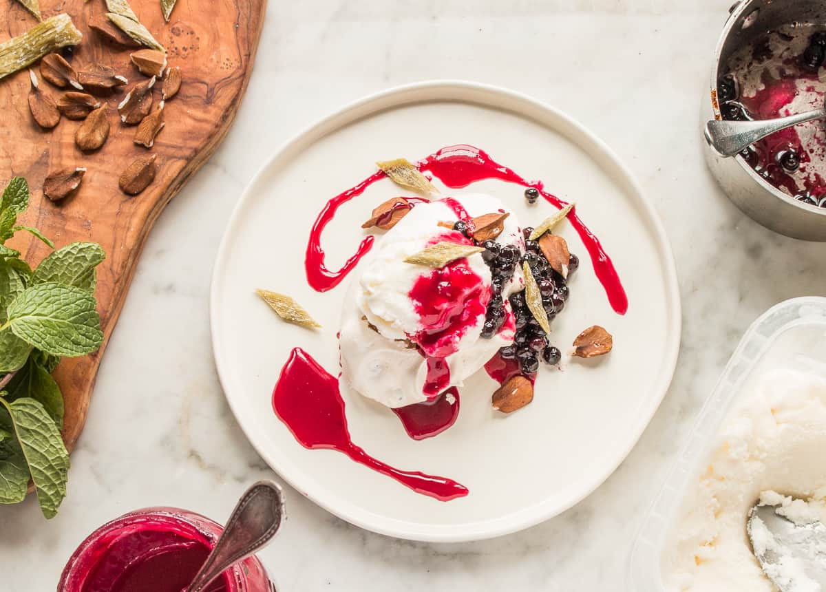 Winter pavlova with meadowsweet ice cream, chokecherry sauce, wild blueberries, butternuts and angelica 