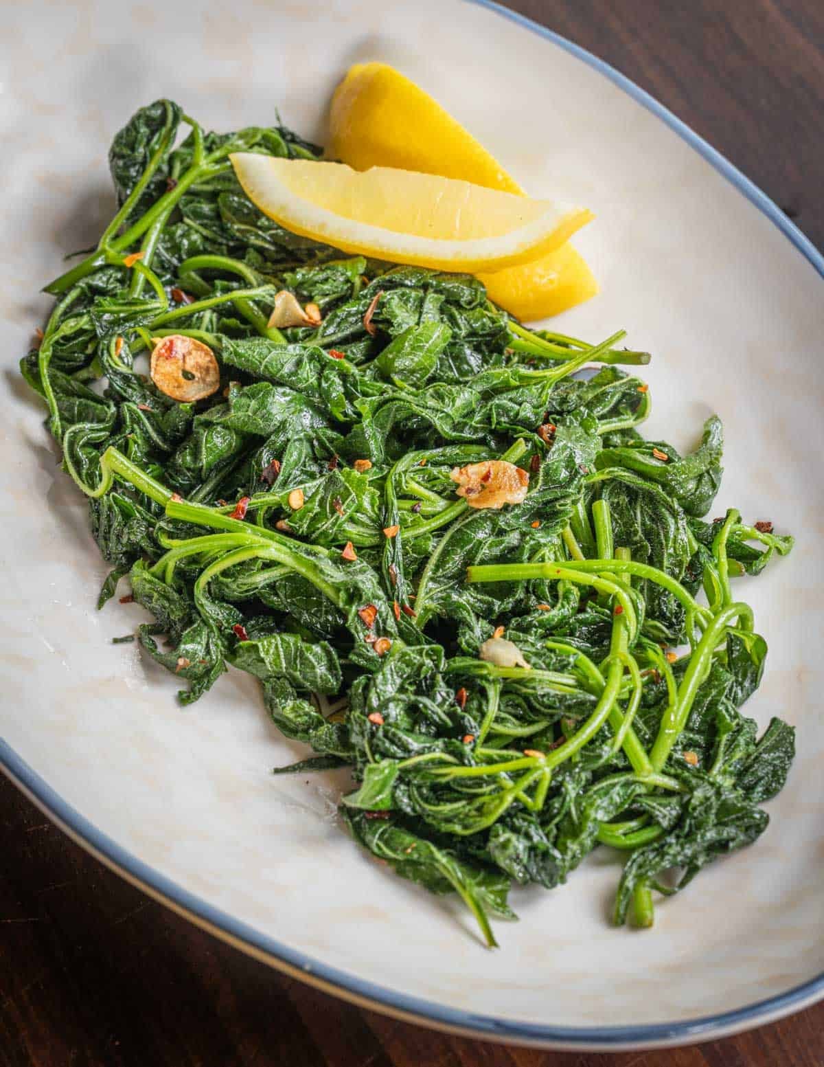 A plate of cooked bellflower greens with garlic, chili olive oil and lemon juice.