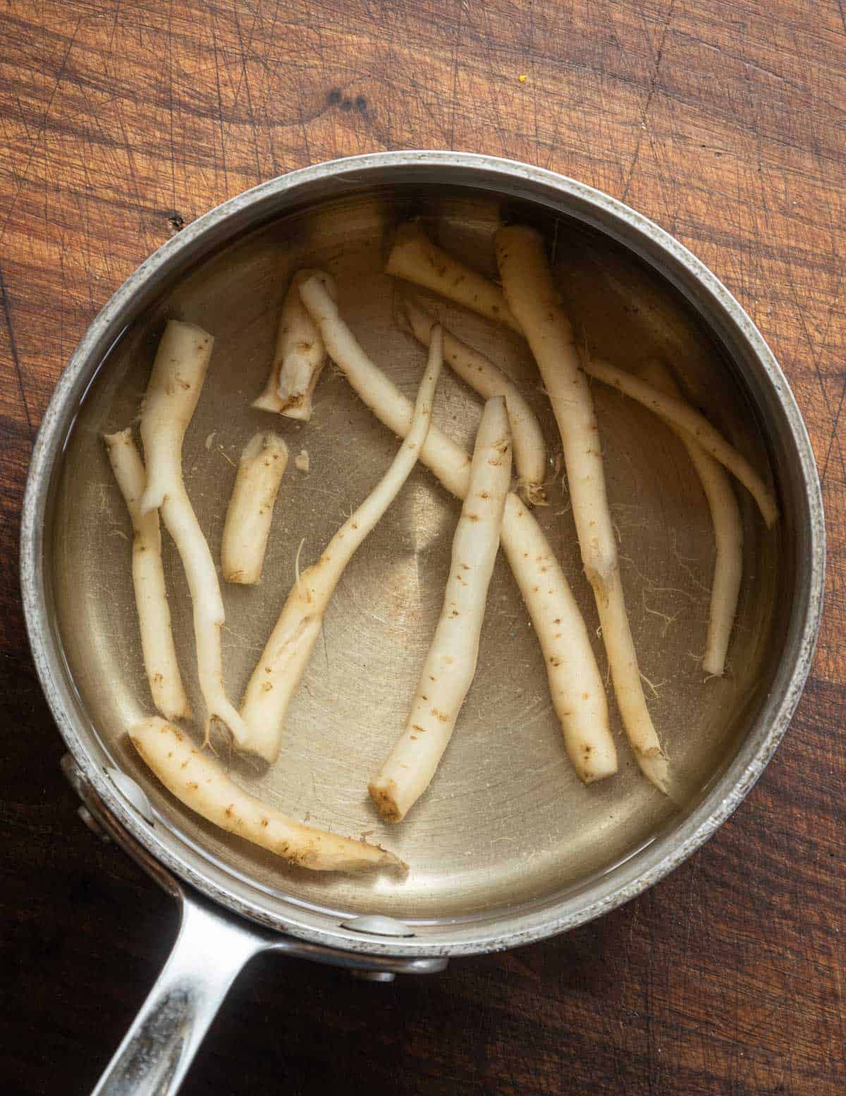 A pot of creeping bellflower roots being boiled until tender.