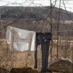 Drying permethrin-soaked clothes on a line outside.