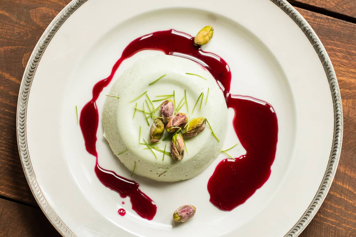 Spruce tip panna cotta recipe with wild grape sauce and pistachios