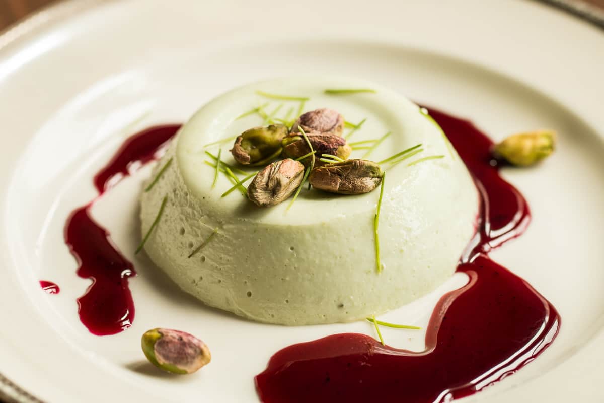 Spruce tip panna cotta recipe with wild grape sauce and pistachios 