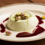 Spruce tip panna cotta recipe with wild grape sauce and pistachios