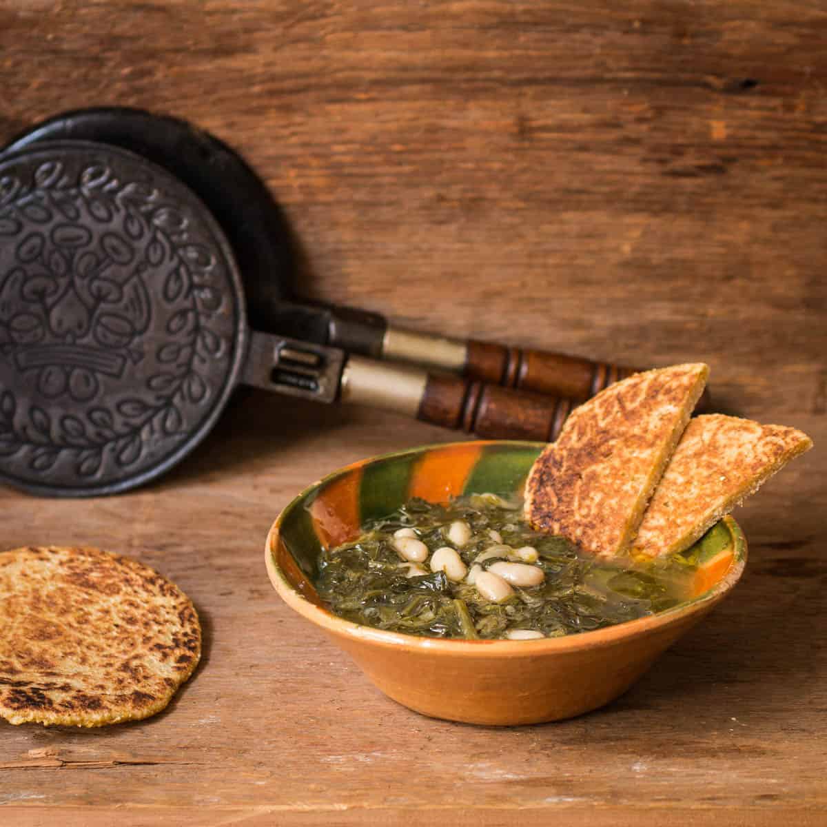 Ministrella Gallicano, an Italian soup of many wild greens and beans served with mignecci cakes