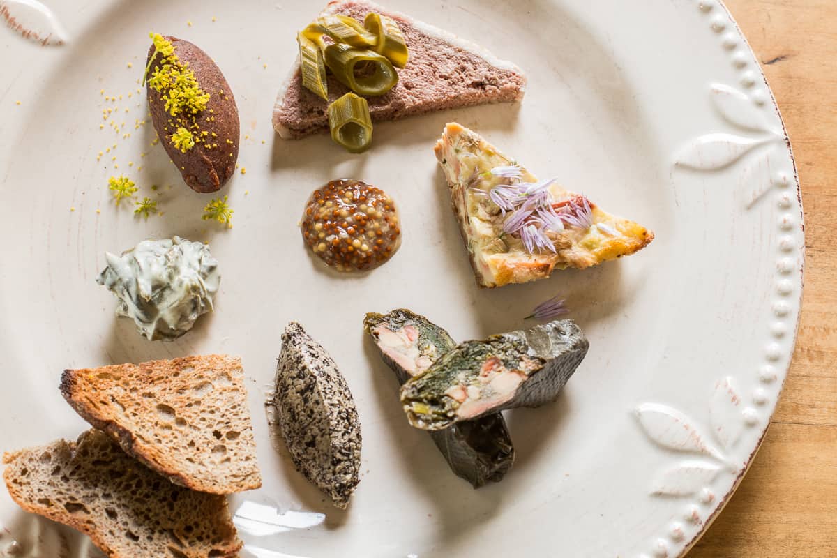 Foragers tasting with squirrel pate, chicken of the woods tart and stuffed grape leaves, black trumpet butter, wild rice sourdough fermented ramps, venison spread