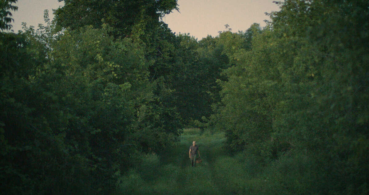 Chef Alan Bergo walking through a hedgerow. Image by Jesse Roesler.