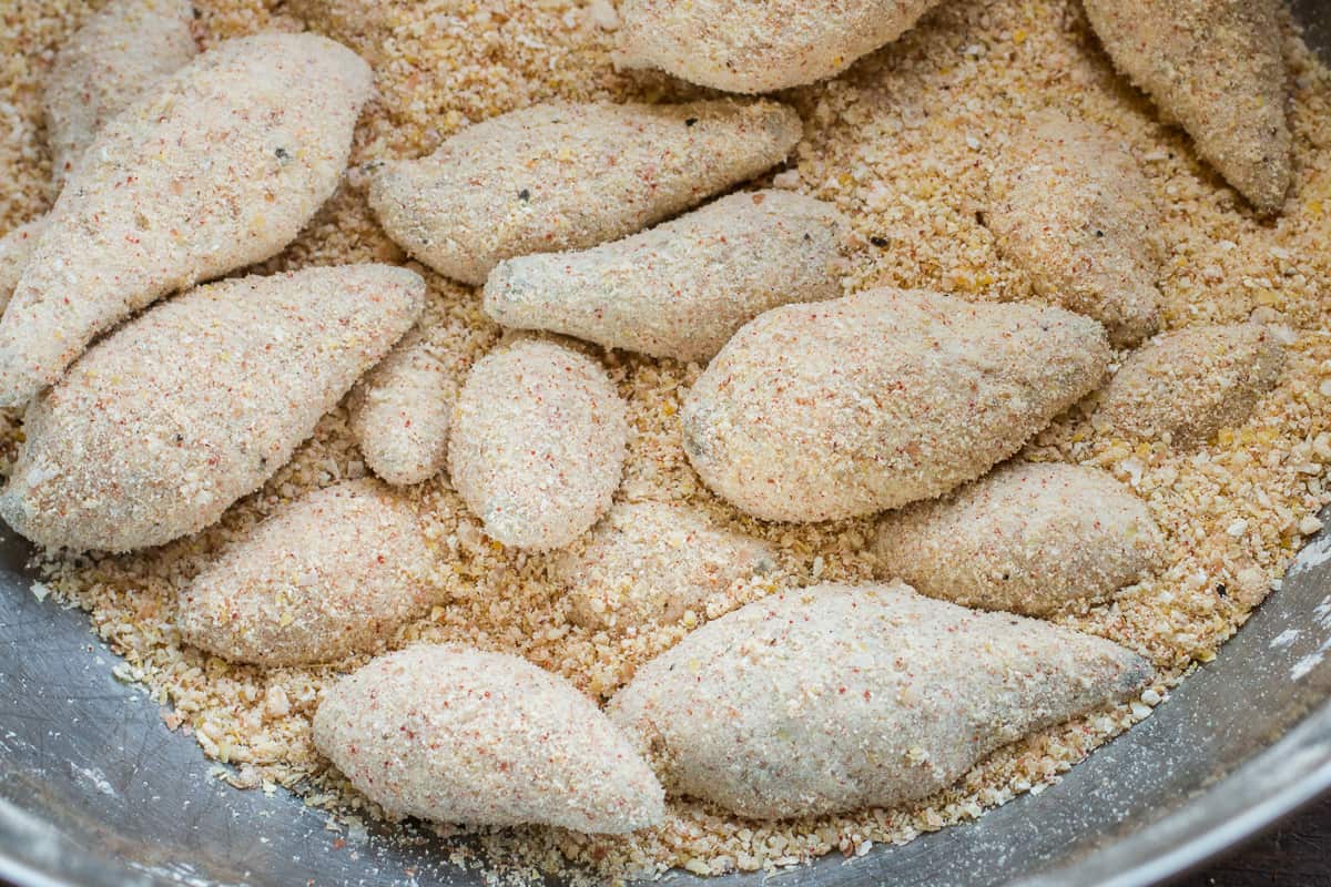 Dredging blanched milkweed pods in seasoned cornmeal