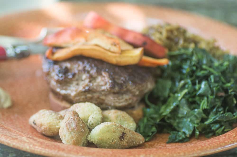 Open faced burger with fried milkweed pods, chicken of the woods mushrooms, and wilted amaranth