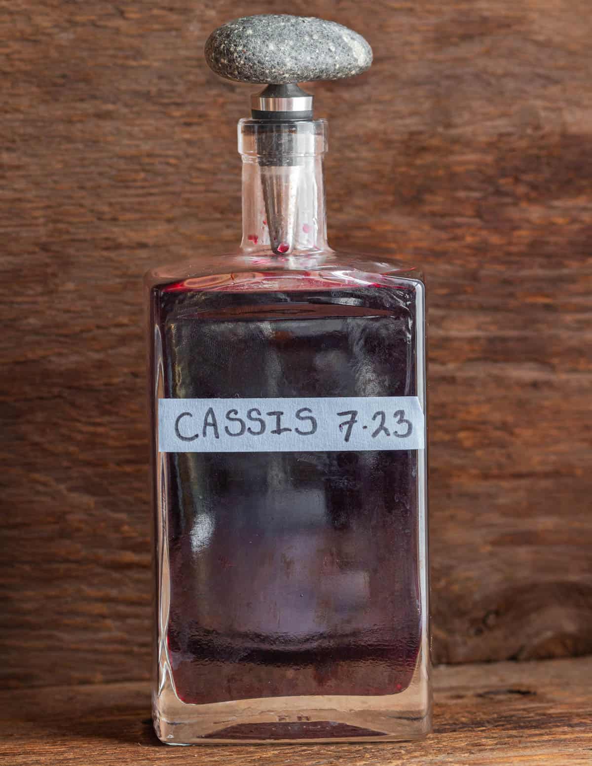 A bottle of homemade creme de cassis with a stopper. 