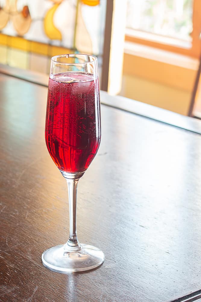 red kir royale champagne drink in a flute showing rich red color. 