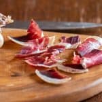 slicing homemade DIY lamb prosciutto