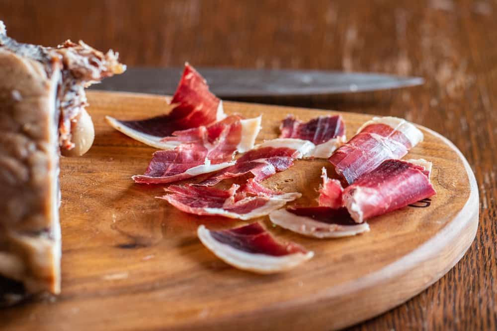 slicing homemade DIY lamb prosciutto 