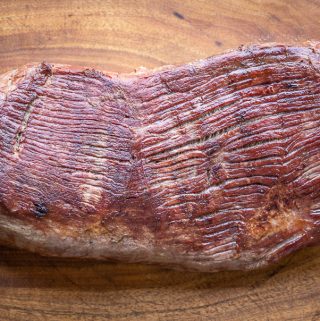 smoked venison leg roast on a wood board