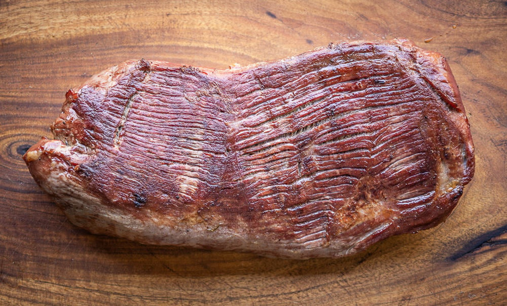 smoked venison leg roast on a wood board