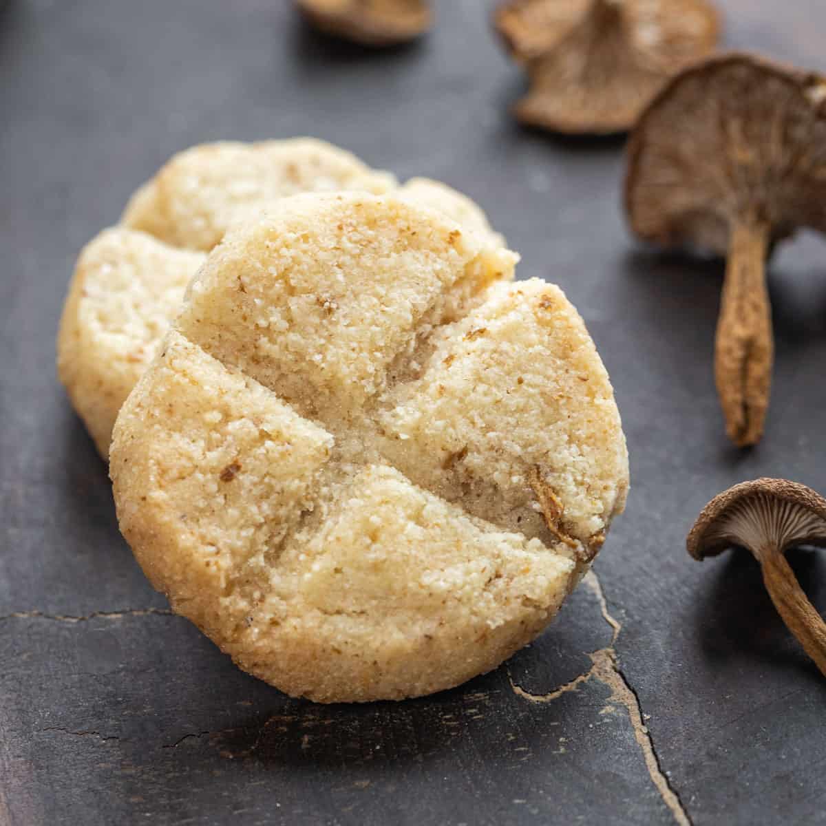 candy cap mushroom cookies on wood with dried candy cap mushrooms