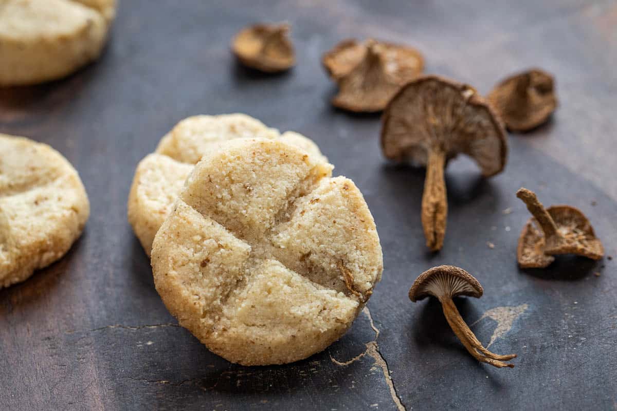 candy cap mushroom cookies on wood with dried candy cap mushrooms