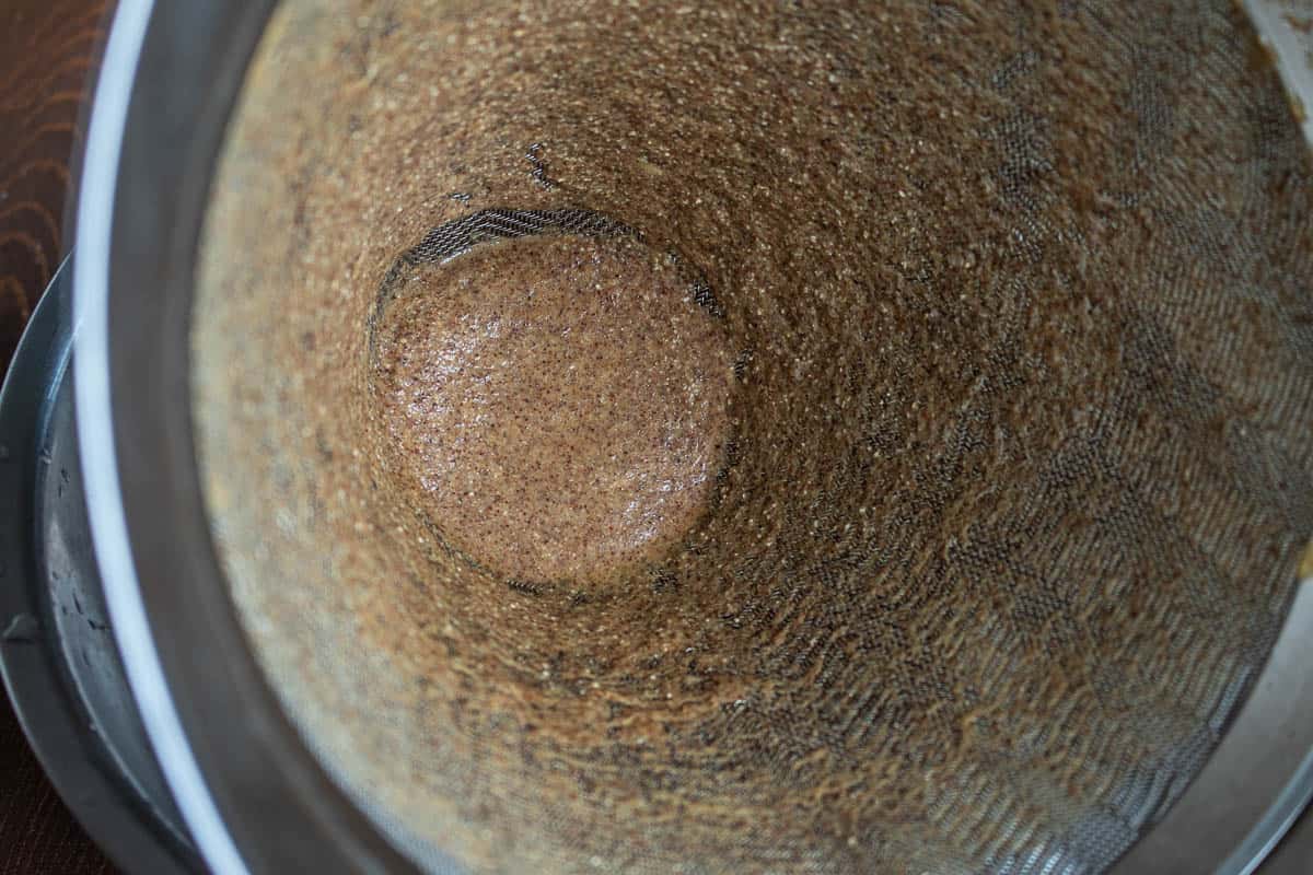 straining hackberry milk through a strainer. 