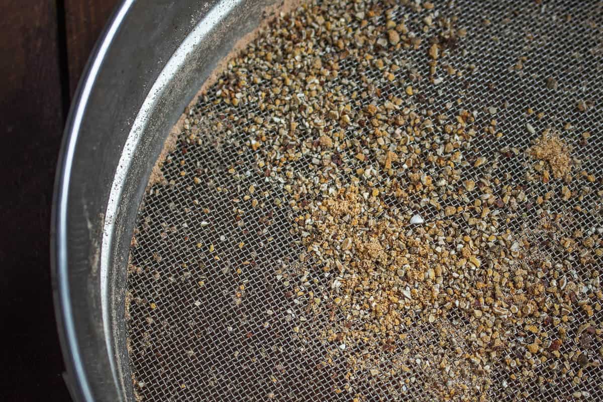 Sifting ground hackberries in a tamis sieve. 