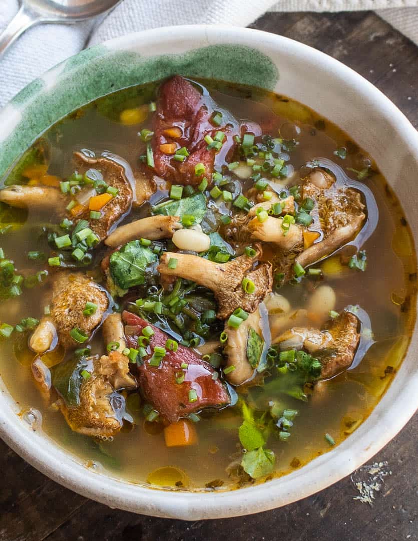 Hedgehog mushroom soup with foraged greens, beans and tomatoes 